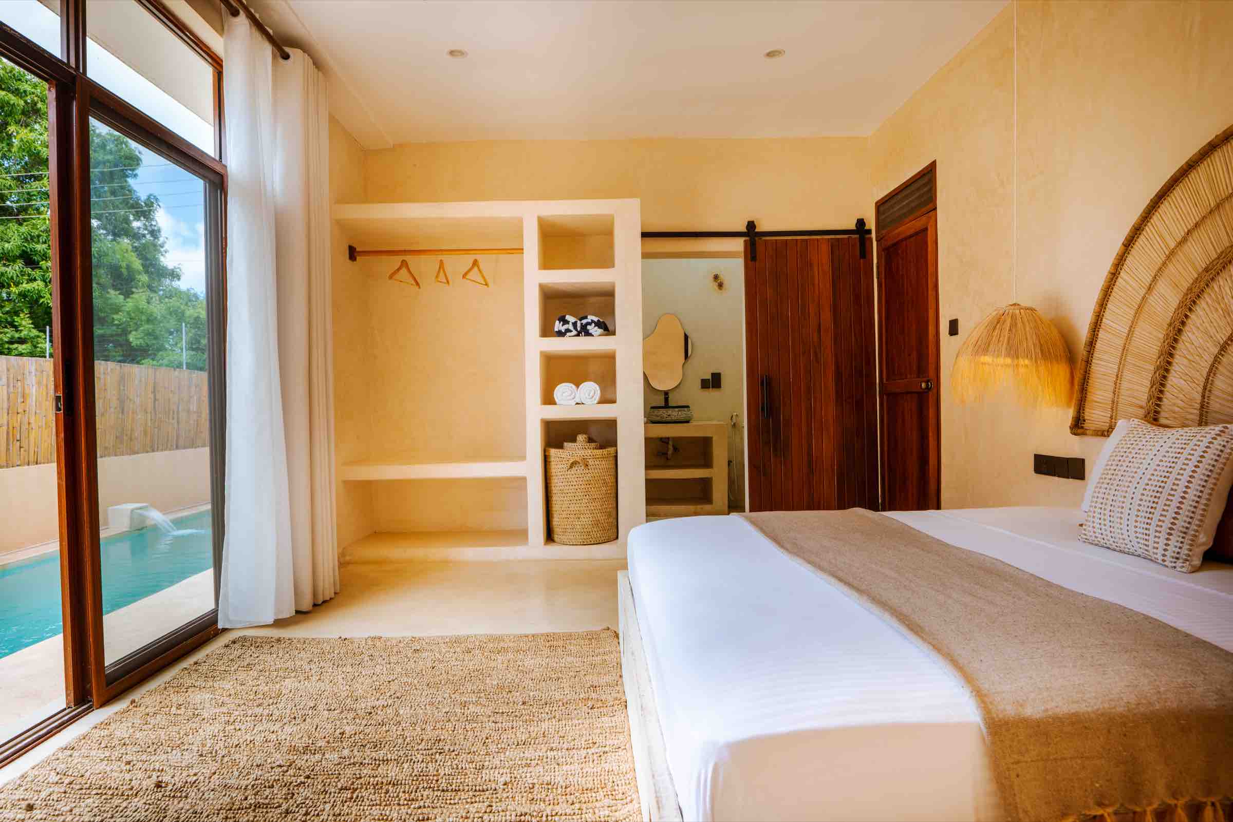 King bed with pool view through glass doors
