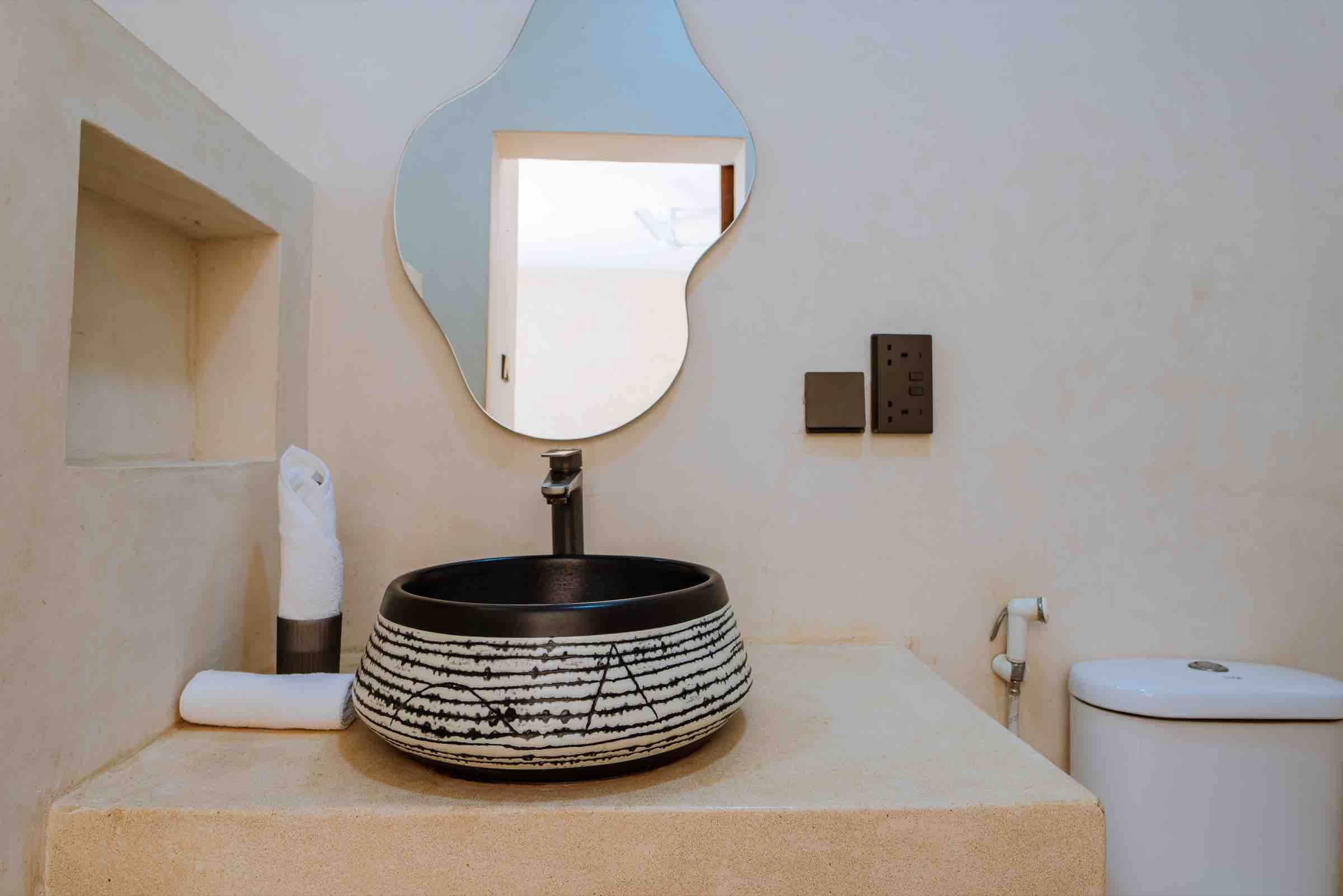Ensuite with ceramic basin and organic mirror